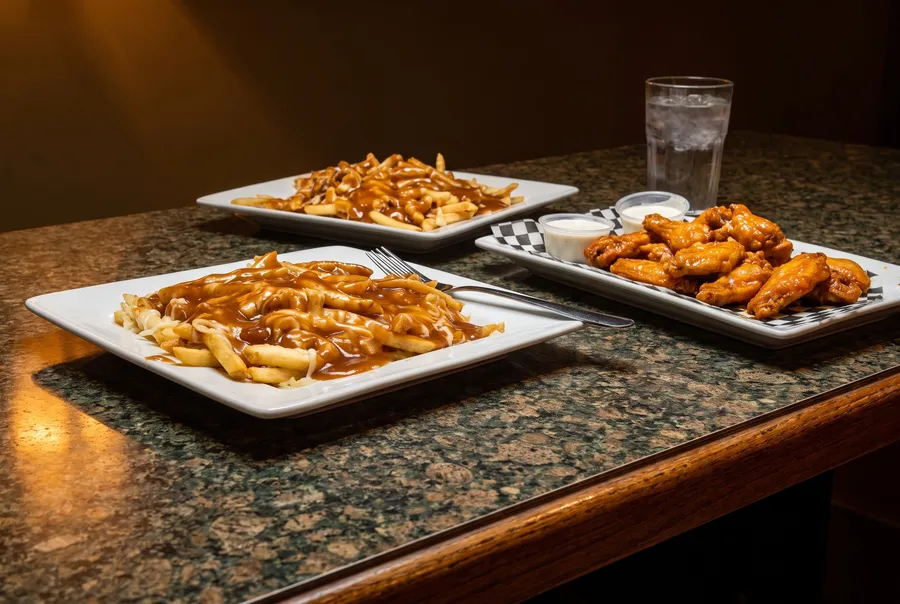Fries with gravy and chicken wings at Casino Dene
